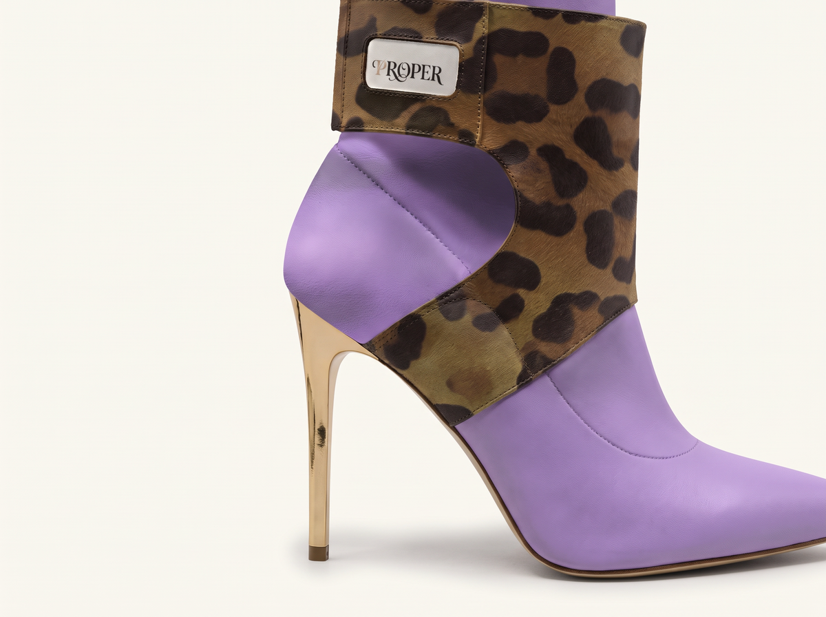 Close-up of the PROPER Signature Boot in LAVENDER: jaguar-print strap with PROPER label and gold stiletto heel