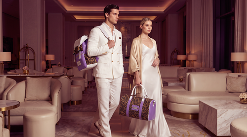 Couple in a hotel lounge carrying the PROPER Signature Backpack and Signature Travel Duffel in LAVENDER